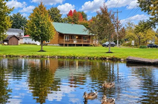 Log cabin at Canadohta Lake with a duck pond out front