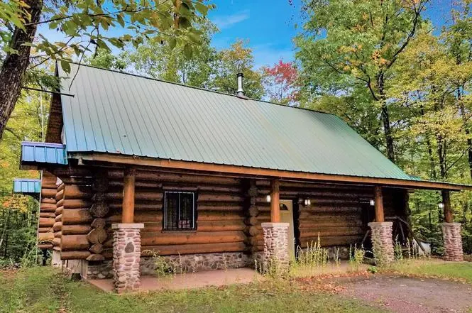 Scandinavian-style log cabin with a stone fireplace on 10 acres